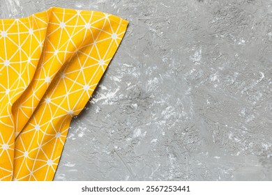 top view with yellow empty kitchen napkin isolated on table background. Folded cloth for mockup with copy space, Flat lay. Minimal style.