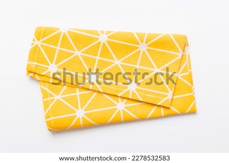 top view with yellow empty kitchen napkin isolated on table background. Folded cloth for mockup with copy space, Flat lay. Minimal style.