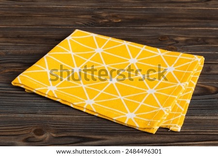 top view with yellow empty kitchen napkin isolated on table background. Folded cloth for mockup with copy space, Flat lay. Minimal style.