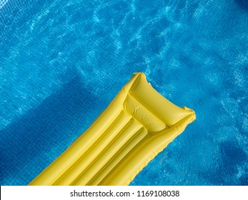 Top View Of A Yellow Inflatable Mattress In An Above Ground Private Backyard Swimming Pool