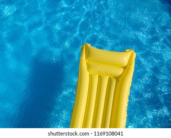 Top View Of A Yellow Inflatable Mattress In An Above Ground Private Backyard Swimming Pool