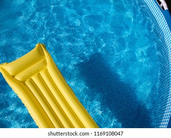 Top View Of A Yellow Inflatable Mattress In An Above Ground Private Backyard Swimming Pool