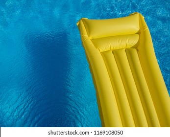 Top View Of A Yellow Inflatable Mattress In An Above Ground Private Backyard Swimming Pool