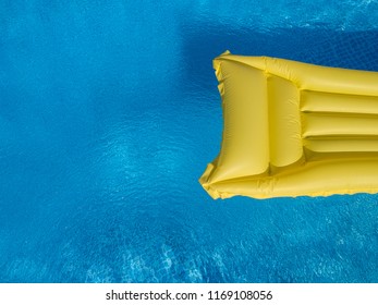 Top View Of A Yellow Inflatable Mattress In An Above Ground Private Backyard Swimming Pool