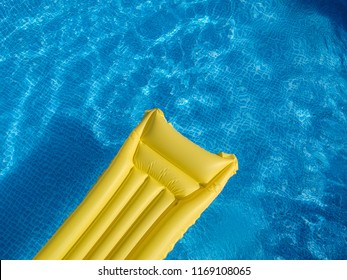 Top View Of A Yellow Inflatable Mattress In An Above Ground Private Backyard Swimming Pool