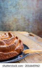 Top View Of Yogurt Sponge Cake On Dark Plate, With Wooden Fork, On Wooden Table, Selective Focus, Vertical, With Copy Space