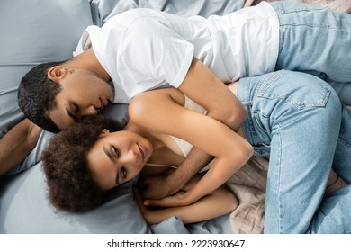 Top View Of Young African American Man With Closed Eyes Lying Near Smiling And Curly Girlfriend