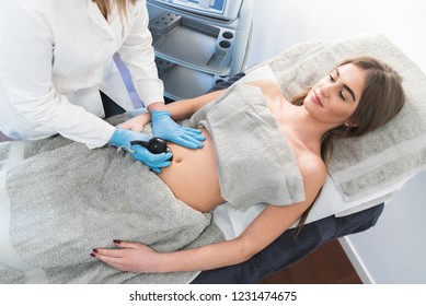 Top view of young beautiful woman on cavitation treatment at beauty clinic.