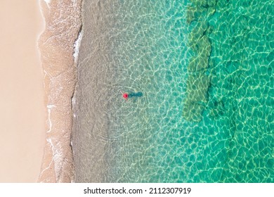 Top View. Young Beautiful Woman In Red Hat Standing And Sunbathe In Sea Water. Drone, Copter Photo. Summer Vacation. View From Above. 