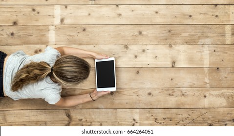 Top View Of Young Blond Girl Playing On Tablet Pc