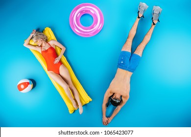 Top View Of Young Couple Resting With Beach Items On Blue, Summer Vacation Concept