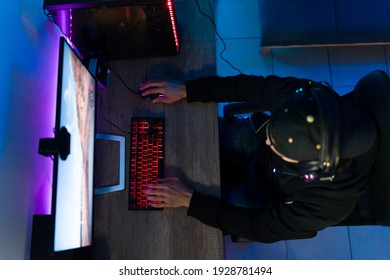 Top View Of A Young Gamer Sitting In Front Of A Gaming Computer With Led Ligths. Attractive Man Playing An Online Video Game At His Desk