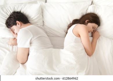 Top View Of Young Indifferent Man And Woman Sleeping Separately Back To Back In Bed After Quarrelling, Difficulties In Relationships, Problems In Sex Life, Family Conflicts, Falling Out Of Love