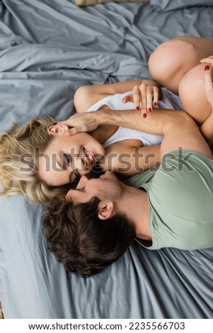 Similar – Young couple in love embracing lying over a bed