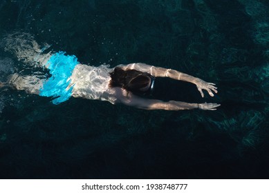 Top view at young man swimming under water. 