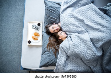 Top view of young man and woman sleeping in bed