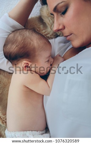 Mother hugging her newborn baby girl