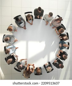 top view. young people shaking hands at a round table meeting - Shutterstock ID 2209513637