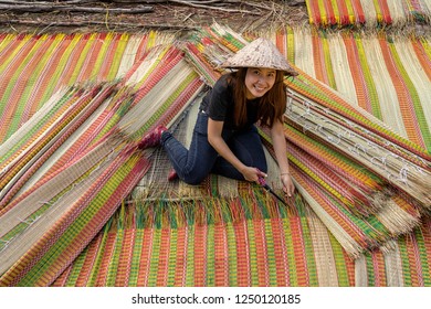 Top view of young Vietnamese craftsman making the traditional vietnam mats with happiness action in the old traditional village at dinh yen, dong thap, vietnam, tradition artist concept
