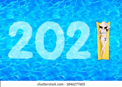 Top View Of Young Woman In Bikini Lying On The Inflatable Float With Number 2021 In The Swimming Pool