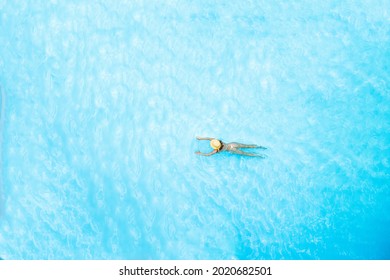 Top view of young woman in bikini and straw hat is swimming in transparent blue sea, lagoon. Aerial, drone view - Shutterstock ID 2020682501