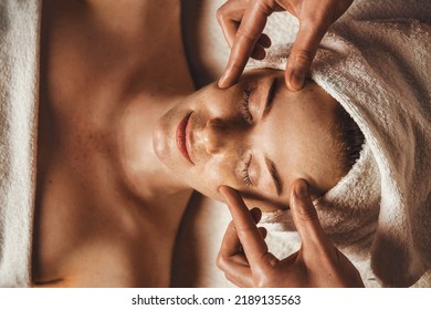 Top view of young woman getting spa massage treatment at beauty spa salon. Face massage. Spa skin and body care. - Powered by Shutterstock