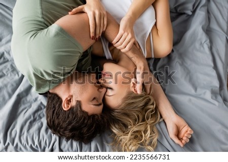 Similar – Young couple in love embracing lying over a bed