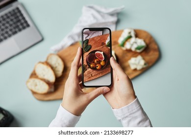 Top view young woman taking aesthetic photo food using smartphone in home studio  copy space