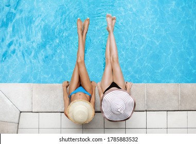 Vista superior de mujeres jóvenes con sombreros de paja relajándose al lado de la piscina