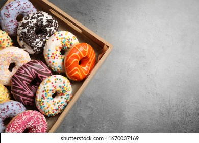 Top view of yummy donuts with sprinkles in box, space for text