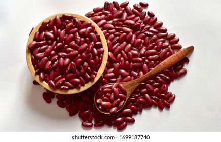 Top Views Of Dried Red Kidney Bean Are Piled Up, Some In A Wooden Bowl And Wooden Spoon Isolated On The White Background, Full Depth Of Field.