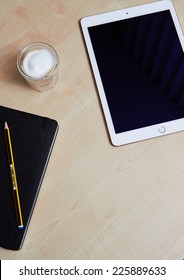 Top Views Showing IPad Air 2 With Touch Id On Wooden Desk And A Coffee