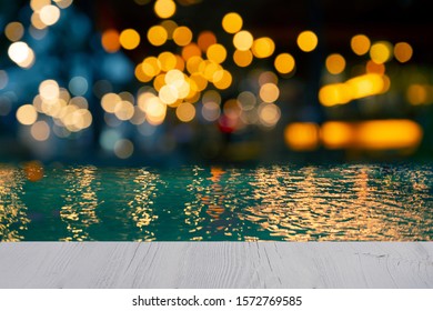 Top Of White Wood Table Blur Bokeh Golden Orange Light Swimming Pool Pool Party In The Dark Night With Blue Water Background