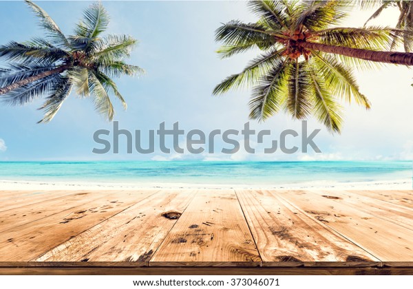 顶部木桌模糊的海洋和椰子树背景 空准备好为您的产品显示蒙太奇 夏季海滩的概念库存照片 立即编辑