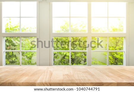 Top of wood table counter on blur window view garden background.For montage product display or design key visual layout