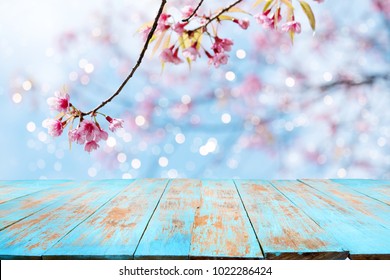 Top of wood table empty ready for your product and food display or montage with pink cherry blossom flower (sakura) on sky background in spring season.