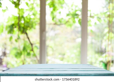 Top Of Wooden Table On Window Glass Blur. Of Green From The Garden Of The Vegetable Garden On A Morning Background. To Display Product Montage.