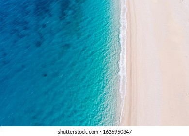Top-down aerial view of a clean white sandy beach on the shores of a beautiful turquoise sea. Greece. - Shutterstock ID 1626950347