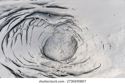 Top-down aerial view of a deep ice moulin and crevasses on the Morteratsch Glacier surface, Switzerland.
