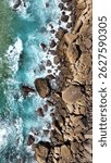 Top-down aerial view of ocean waves crashing on rocky shore, Algarve coast, Portugal