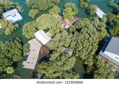 Top-Down Drone Angle Above Major Historic Flooding Outside Of Austin Texas Along The Colorado River. Debris And Destruction Float Around Homes One Is Completely Destroyed An Underwater By Floodwaters