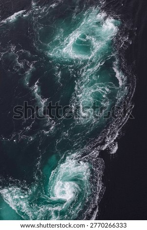 Top-down drone perspective of Saltstraumen, creating mesmerizing turquoise and white water vortexes and foam patterns in the deep ocean