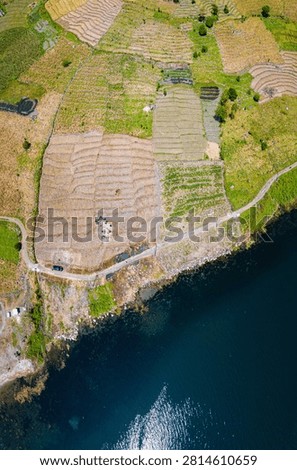 Topdown drone view of calm lakeside near Toba Lake at Silalahi in Desa Binangara, Samosir, Sumatra Utara, Indonesia