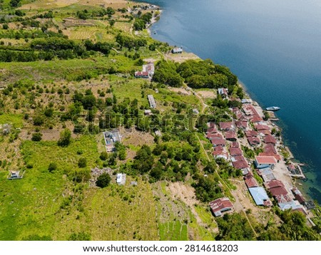 Topdown drone view of idyllic lakeside scenery near Toba Lake at Silalahi in Desa Binangara, Samosir, Sumatra Utara, Indonesia