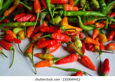 Top-down or Flat lay view of a bunch of datil peppers or cabai rawit (also known as Capsicum frutescens, chili pepper, cabai rawit merah) is freshly harvested by Indonesian Local Farmers from fields