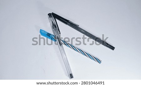 A top-down shot of three various plastic ballpoint pens arranged neatly against a clean white background, perfect for school, office, and stationery concepts.
