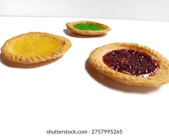 A top-down, slightly elevated perspective photograph featuring three small Indonesian milk tarts (Pai Susu) arranged in a triangular pattern against a clean, brilliant white background