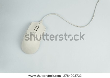 A top-down studio shot of a modern, white wired computer gaming mouse with an elegant matte finish and a curved white cable. Captured in a minimalist style against a solid, seamless whte background, creating a high-contrast visual. Perfect for technology blogs, e-sports branding, PC hardware reviews, and e-commerce product banners.