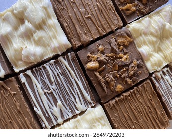 Top-down view of assorted chocolate slabs with white, milk, and dark chocolate drizzle and toppings. Ideal for food blogs, bakery ads, packaging, and dessert-related content.