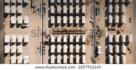 Top-Down View of Battery Storage Containers in Large-Scale Renewable Energy Project in Desert under Construction